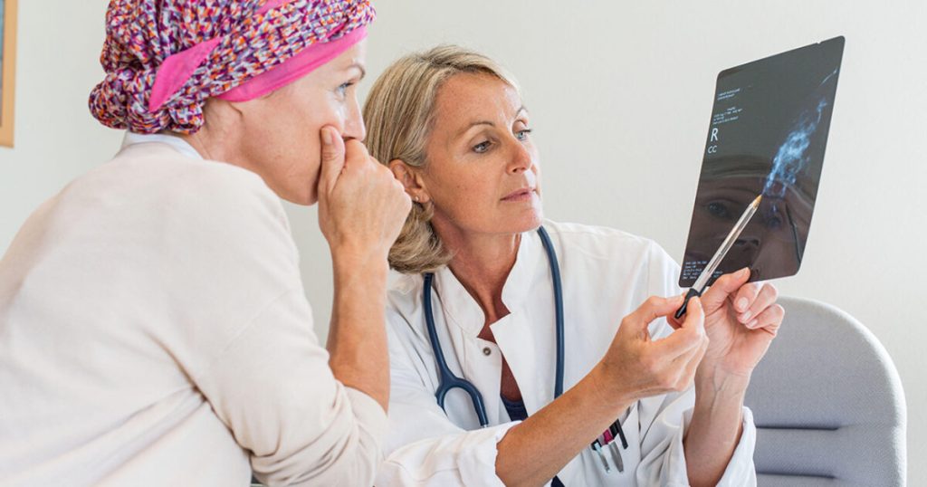Doctor commenting on a mammography to her patient.